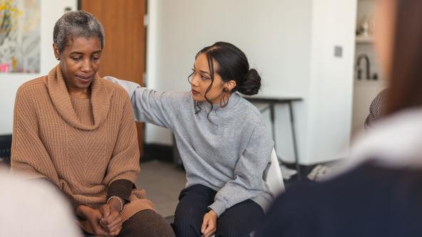 One patient comforts another in group counselling