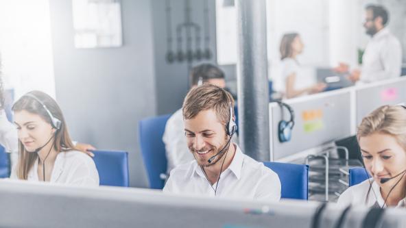 Image of people in an office on the phone using headsets