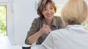 Two office workers having a meeting at a desk.