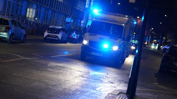 An ambulance driving through a city centre.