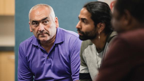 A man listening during a diverse group counselling session.