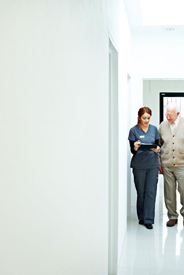 A nurse and a patient walking down a corridor.